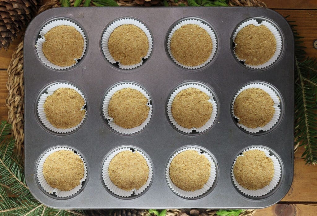 Filling the muffin paper liners with the cookie mixture for a delightful, crunchy cake base.